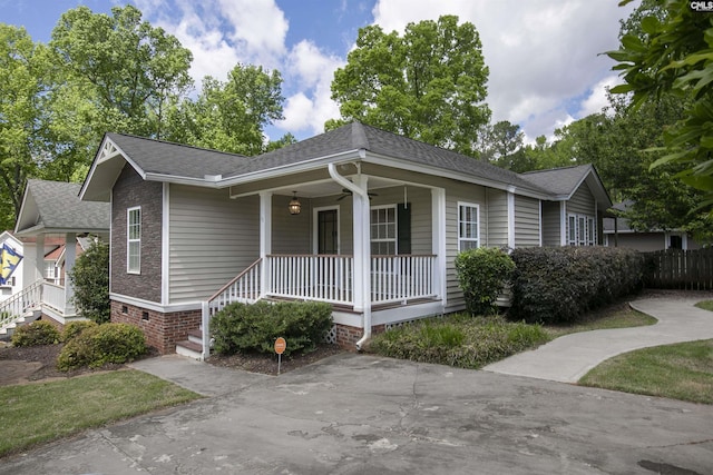 view of front of house featuring ceiling fan, roof with shingles, and covered porch