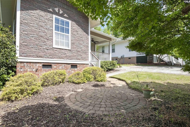 view of property exterior featuring stone siding, a porch, stairway, crawl space, and a ceiling fan