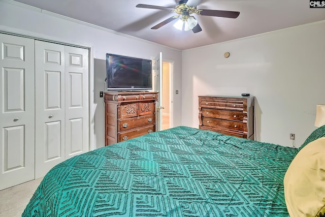 carpeted bedroom featuring a closet, ornamental molding, and ceiling fan