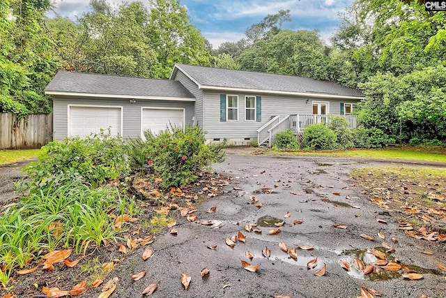 ranch-style house featuring fence, roof with shingles, crawl space, an attached garage, and driveway