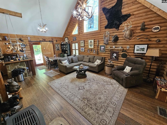 living area featuring high vaulted ceiling, visible vents, rustic walls, and a notable chandelier