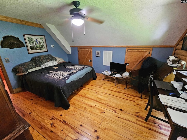 bedroom featuring a textured ceiling, ceiling fan, vaulted ceiling, and hardwood / wood-style flooring