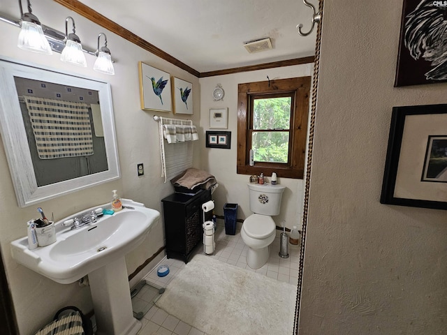 bathroom featuring toilet, tile patterned floors, baseboards, visible vents, and ornamental molding