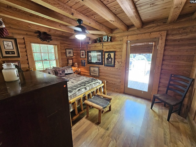 dining space with log walls, beam ceiling, wooden ceiling, a ceiling fan, and light wood-style flooring