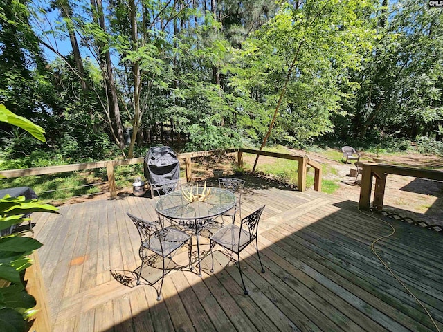 wooden deck with outdoor dining space and a grill