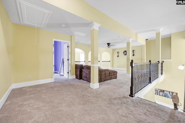 spare room with carpet flooring, a ceiling fan, baseboards, and attic access