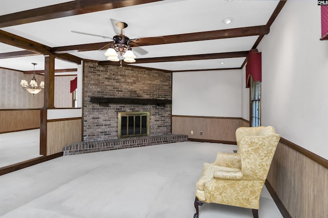 living area with wainscoting, wooden walls, and beamed ceiling