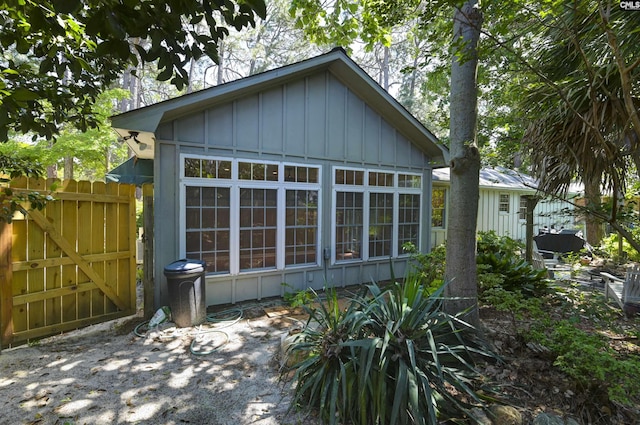 view of side of property with board and batten siding and fence
