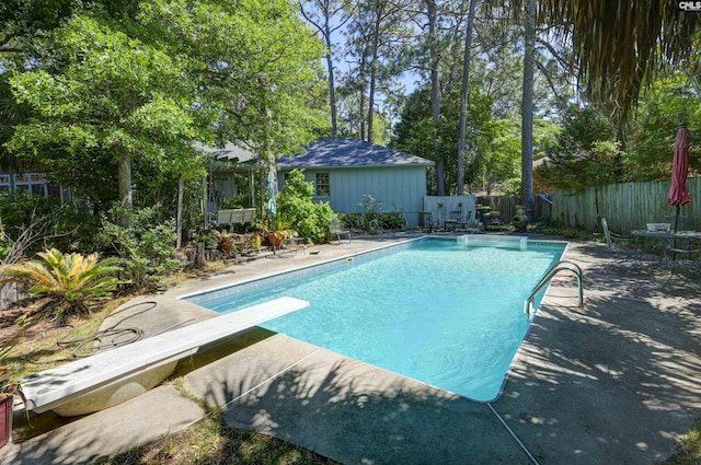 view of swimming pool with a fenced in pool, a patio, a diving board, and a fenced backyard