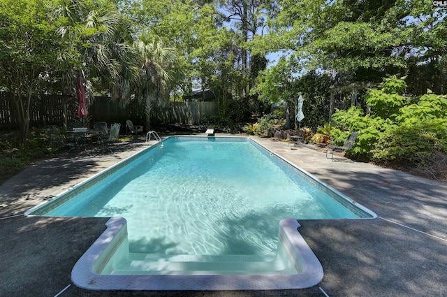 outdoor pool with a fenced backyard and a patio area