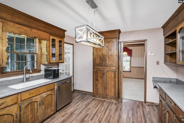 kitchen featuring a sink, a chandelier, decorative light fixtures, light wood-type flooring, and stainless steel dishwasher