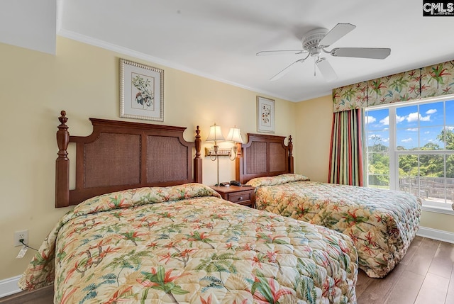 bedroom with baseboards, ornamental molding, a ceiling fan, and wood finished floors