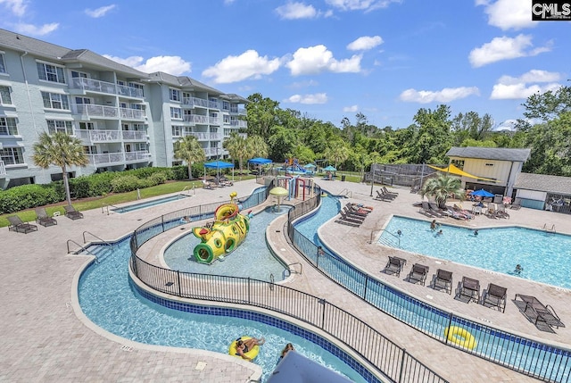 community pool with a patio and fence