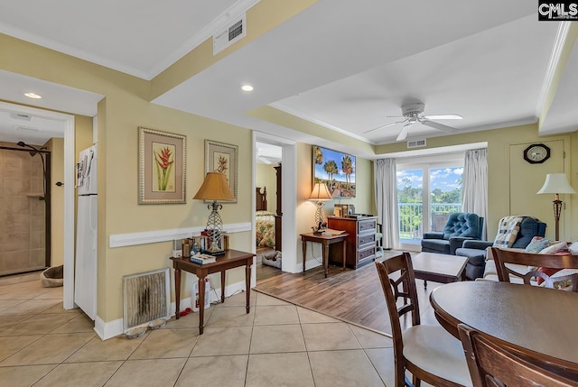 interior space with visible vents, ornamental molding, baseboards, a ceiling fan, and light tile patterned floors