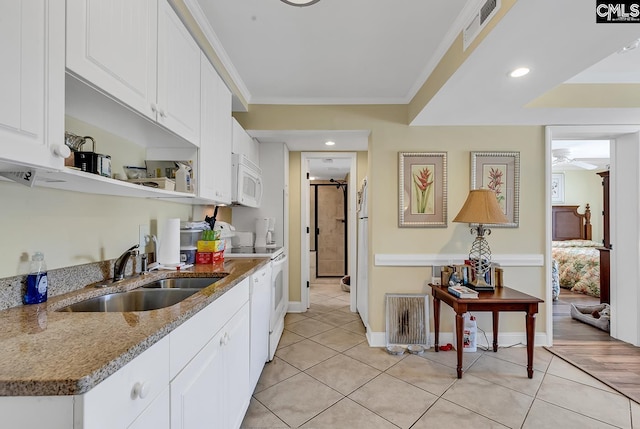 kitchen with visible vents, a sink, light tile patterned floors, and white appliances