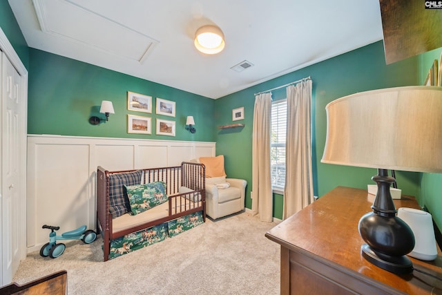 carpeted bedroom with visible vents, attic access, and a closet