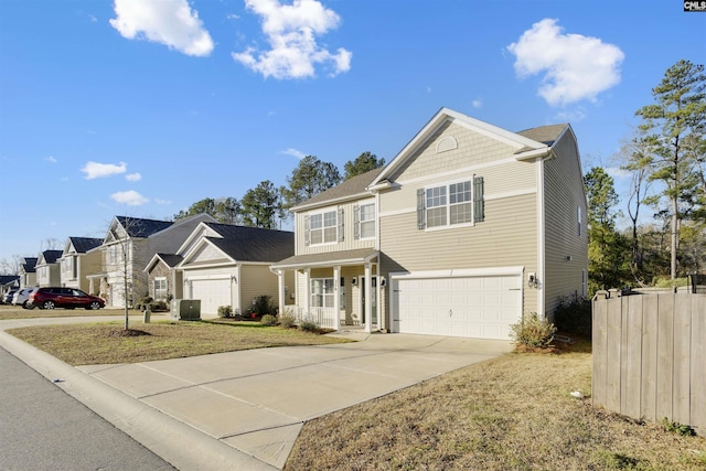 view of front of home with fence, a front yard, an attached garage, driveway, and a porch