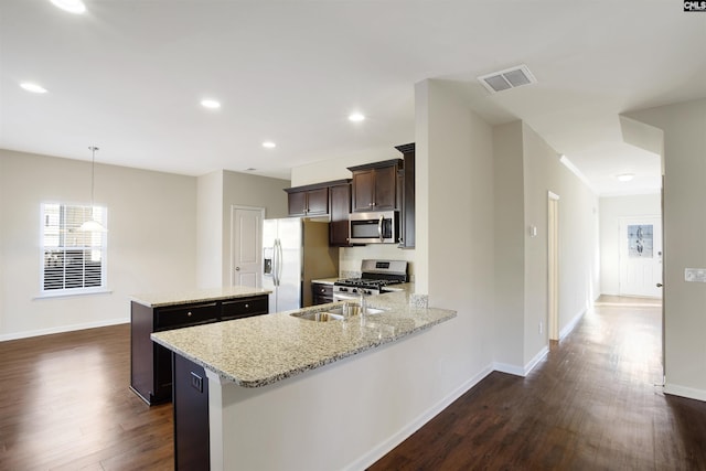 kitchen with visible vents, dark wood-style flooring, dark brown cabinets, a center island, and stainless steel appliances