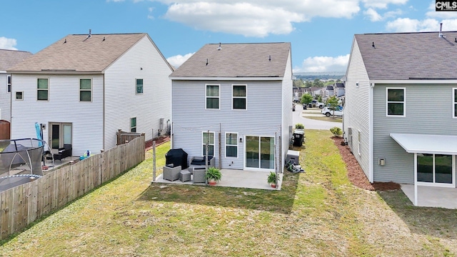 back of house with a patio, a lawn, fence, and a residential view