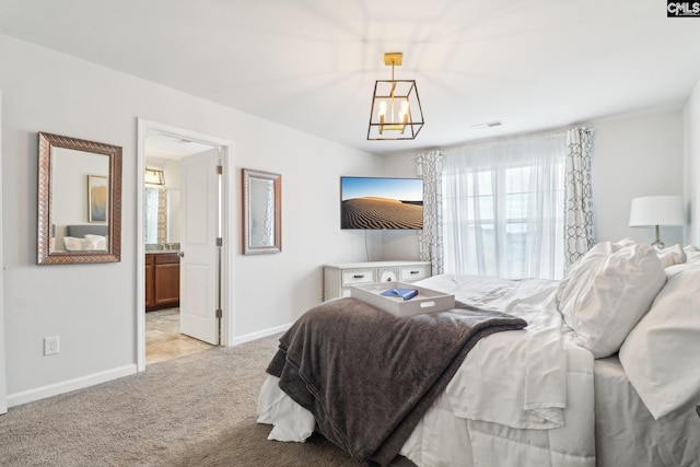 bedroom with visible vents, an inviting chandelier, baseboards, ensuite bathroom, and light colored carpet