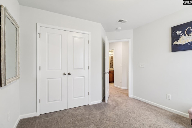 unfurnished bedroom with visible vents, baseboards, carpet floors, and a closet