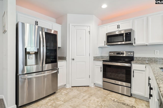 kitchen with stainless steel appliances, light stone countertops, recessed lighting, and white cabinetry