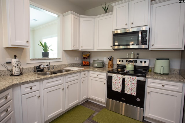 kitchen featuring a sink, white cabinets, ornamental molding, and stainless steel appliances