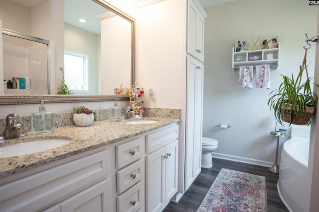 full bathroom with toilet, baseboards, a sink, and wood finished floors