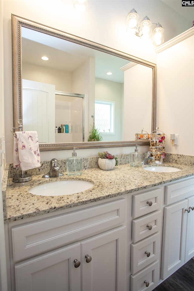 full bath with a sink, a stall shower, recessed lighting, and double vanity