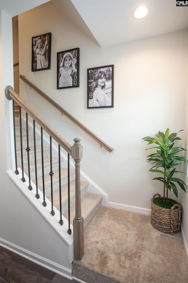 stairway featuring baseboards, recessed lighting, and carpet