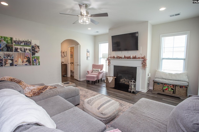 living area with arched walkways, a ceiling fan, visible vents, and recessed lighting
