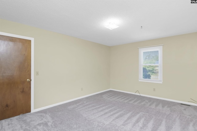 spare room featuring baseboards, carpet flooring, and visible vents