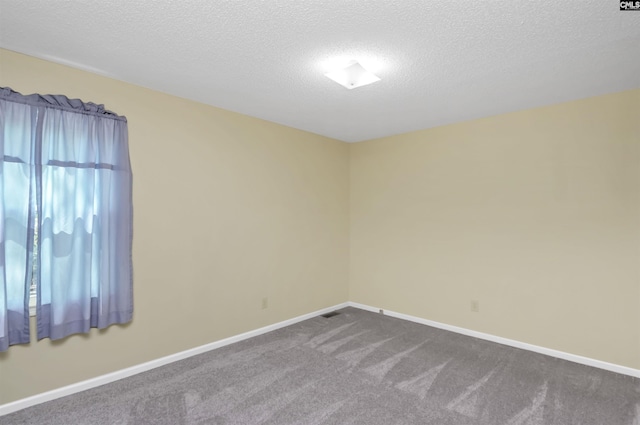 empty room featuring baseboards, a textured ceiling, and dark carpet