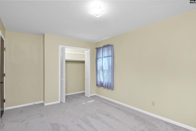 unfurnished bedroom with carpet floors, baseboards, a closet, and a textured ceiling