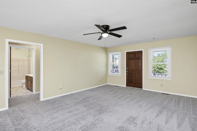 interior space featuring plenty of natural light, baseboards, ceiling fan, and light carpet