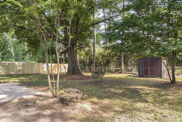 view of yard featuring a storage unit, a fenced backyard, and an outdoor structure