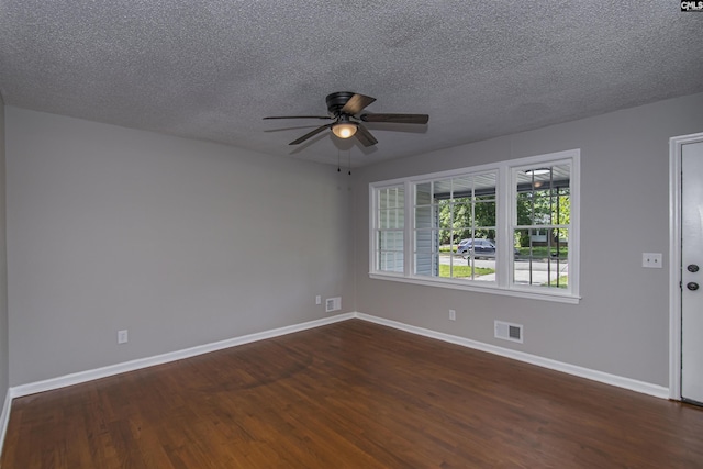 unfurnished room featuring a ceiling fan, a textured ceiling, visible vents, baseboards, and dark wood-style floors
