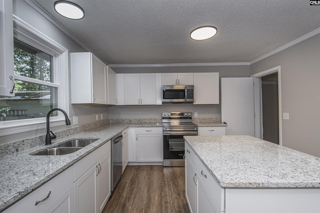 kitchen featuring a sink, a textured ceiling, appliances with stainless steel finishes, and dark wood finished floors