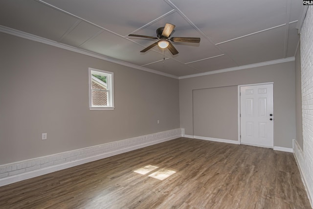 spare room featuring baseboards, a ceiling fan, wood finished floors, and ornamental molding