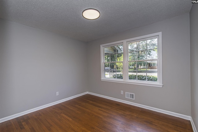 unfurnished room featuring baseboards, a wealth of natural light, dark wood-style flooring, and visible vents