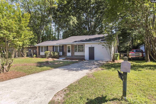 ranch-style house featuring a front lawn and concrete driveway