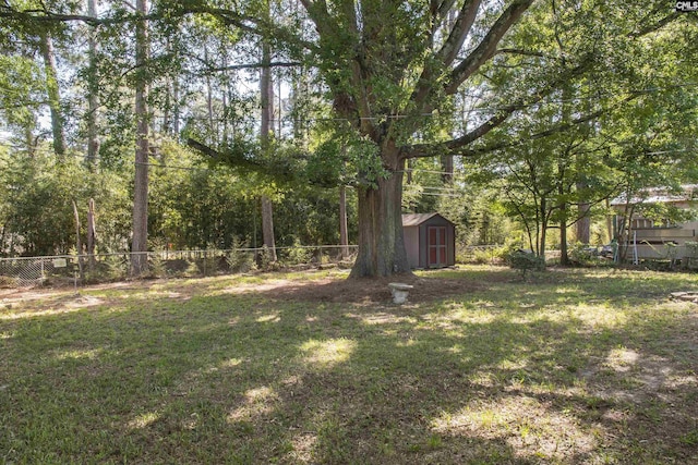 view of yard featuring an outbuilding, a fenced backyard, and a storage unit