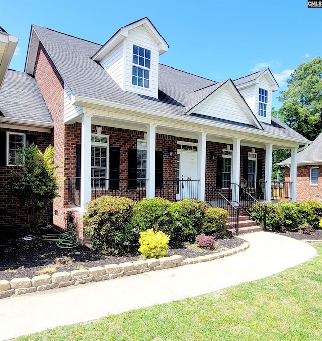 24 Mauser Dr, Lugoff, SC 29078 - cape cod-style house with a shingled roof, a porch, and brick siding