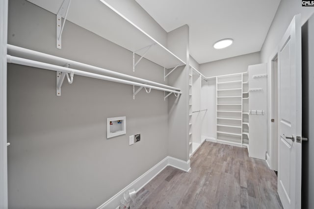 laundry area featuring laundry area, washer hookup, baseboards, electric dryer hookup, and wood finished floors