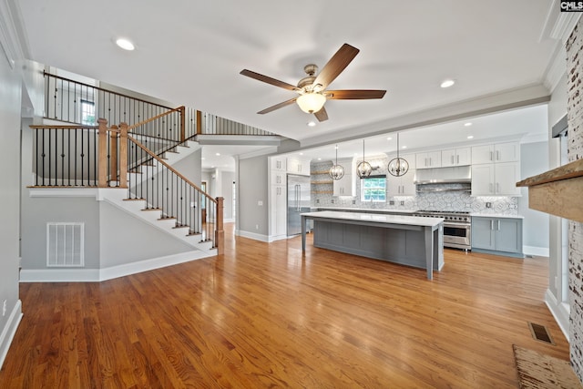 interior space with visible vents, baseboards, ceiling fan, and light wood finished floors