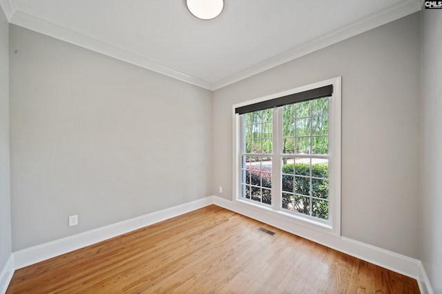 empty room with crown molding, baseboards, and wood finished floors