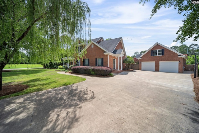 view of front of home with a front lawn, fence, brick siding, concrete driveway, and a detached garage