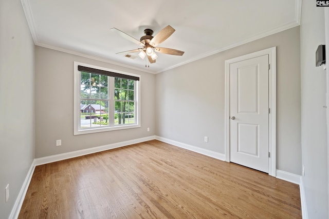 empty room with ceiling fan, ornamental molding, baseboards, and light wood-type flooring