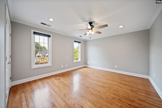 empty room with a ceiling fan, visible vents, baseboards, light wood finished floors, and ornamental molding