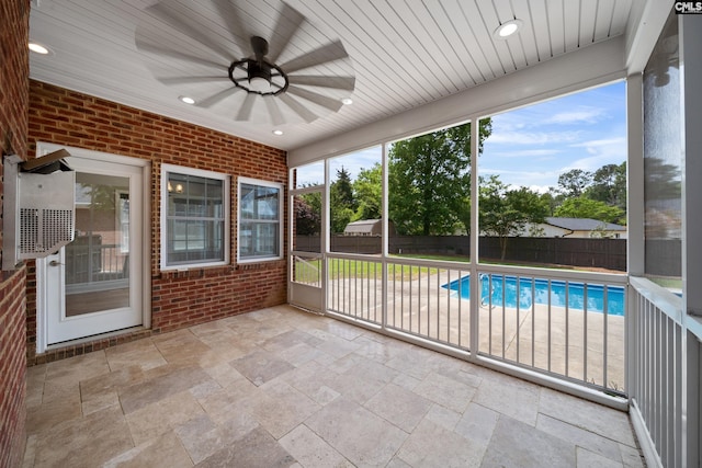 unfurnished sunroom with ceiling fan